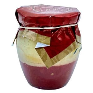 Sauberes Bild eines spanischen Käse- und Wurstaufstrich im Glas, verpackt mit einer roten Papierhaube, präsentiert auf der Webseite Mareni – direkt aus Spanien.