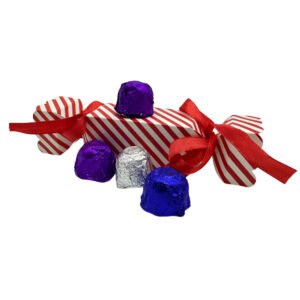 Bunte Schokoladenpralinen in Geschenkverpackung mit roter Schleife, aus Spanien importiert, ideal für Süßwarenliebhaber und Geschenkideen.