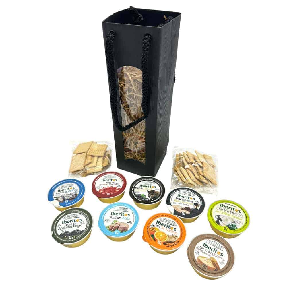 Feinkostprodukte aus Spanien, Mareni - direkt aus Spanien, mit einer Auswahl an iberischem Schinken, Pasteten und Toasts, präsentiert in einem eleganten schwarzen Geschenkkorb.