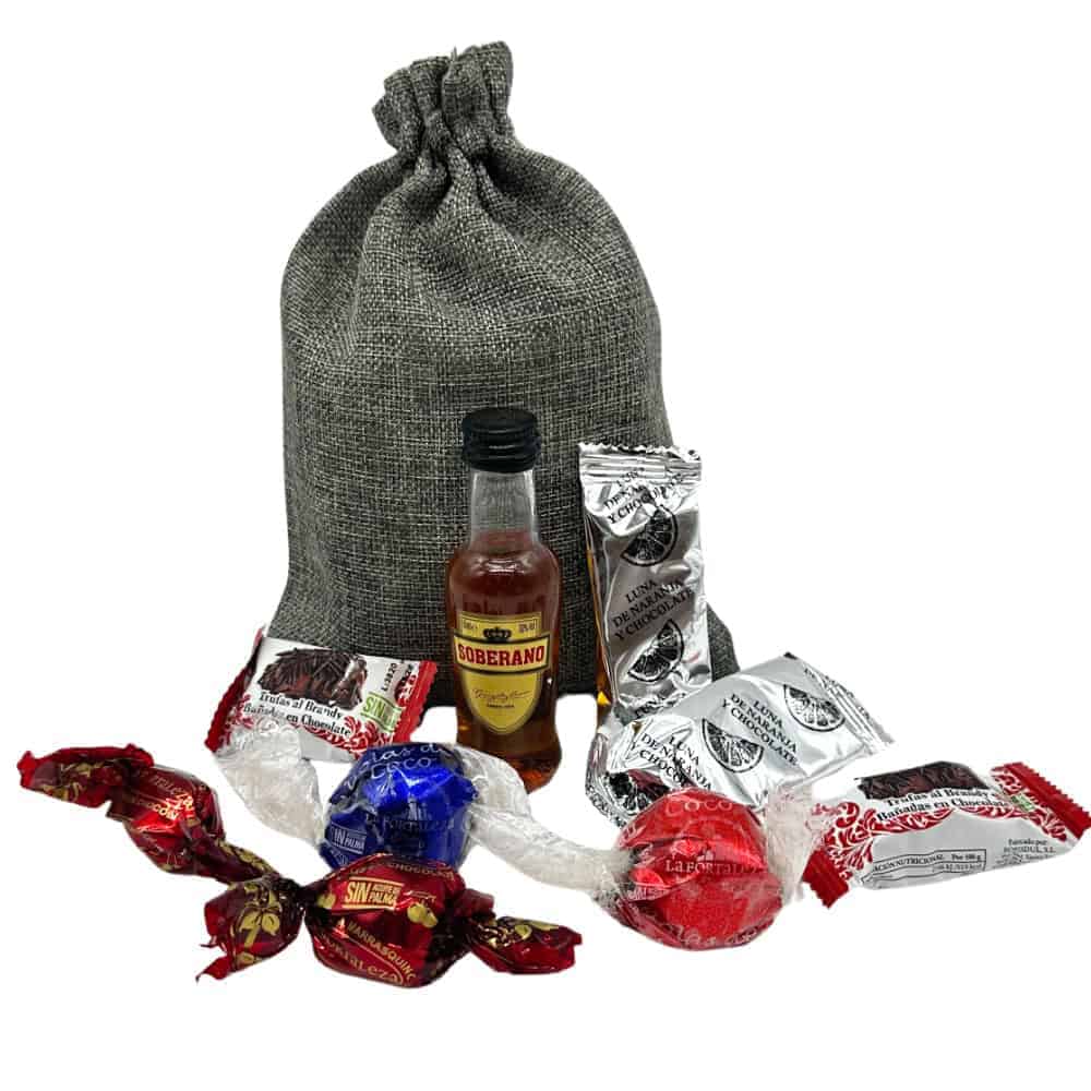 Knusprige spanische Süßigkeiten, Likör, Schokolade und Bonbons vor einem Stoffjersey-Beutel, direkt aus Spanien, ideal für spanische Süßwarenliebhaber und Geschenkideen.