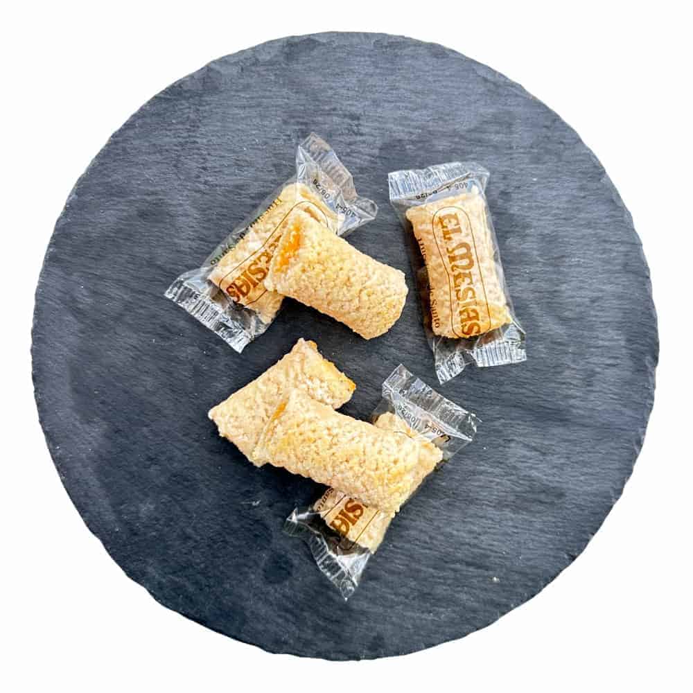 Knusprige spanische Turron-Snacks in Verpackung auf dunklem Steinuntergrund, direkt aus Spanien, ideal für Naschkatzen und Feinschmecker.