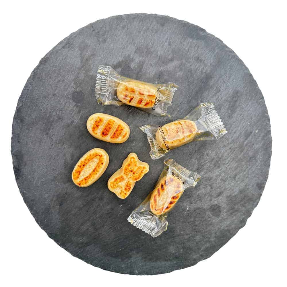 Zuckerwatteigel in diversen Geschmacksrichtungen, einzeln verpackt, auf schwarzem Steinplatte, typisch spanischer Snack, handgefertigt, süß und lecker, perfekt für Naschkatzen, ideal zum Teilen und Genießen.