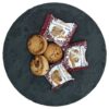 Mandel-Schmalzgebäck Mantecados de Almendra gebacken, drei Stück neben einzeln verpackten Keksen auf dunklem Teller.